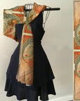 An elegant scarf featuring the artwork 'Painting' from Alphonse Mucha's series 'The Arts'. The scarf displays a serene muse, surrounded by floral patterns and circular motifs, rendered in soft, flowing viscose.