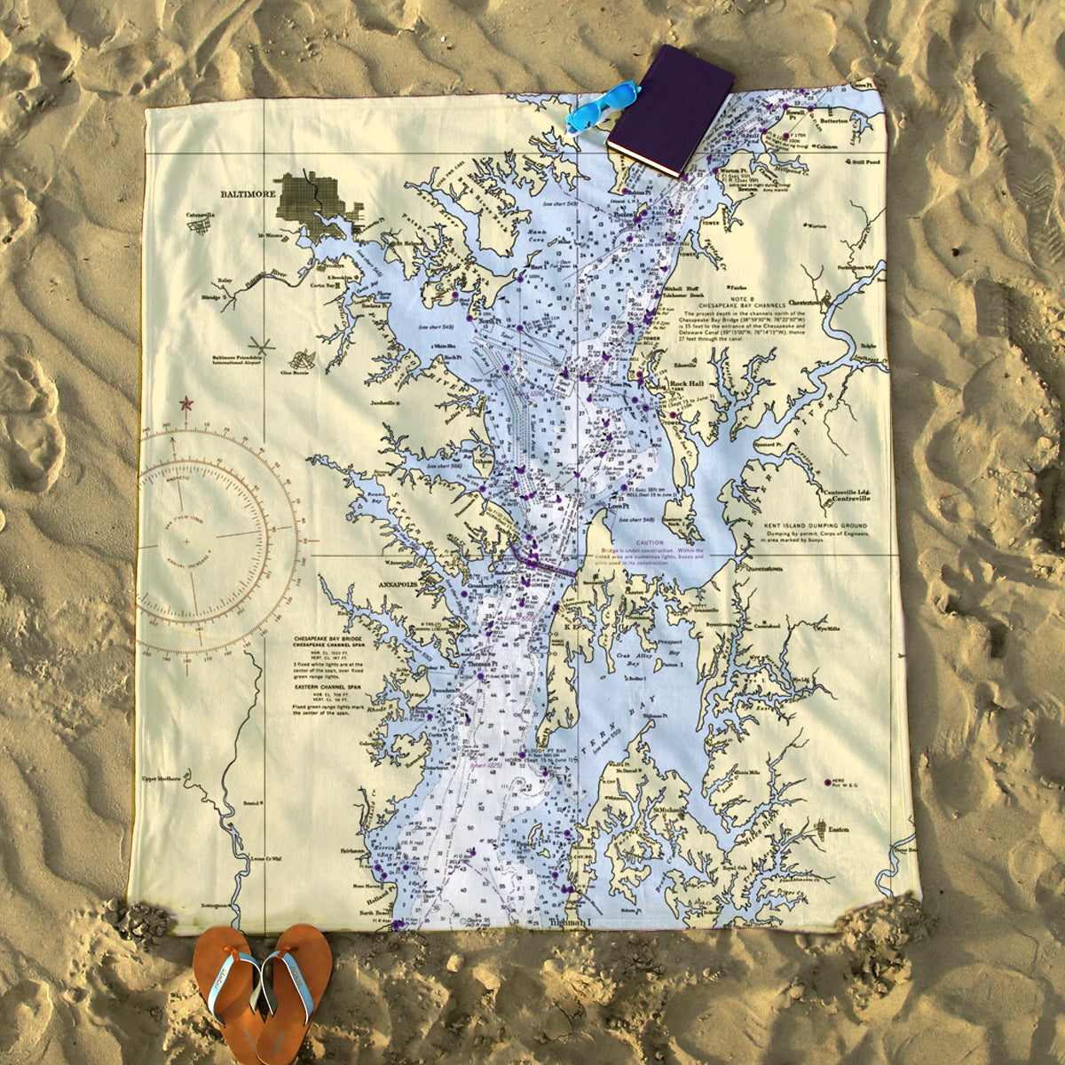 Map of a lake on sand with a heart-shaped object and book