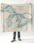 Person holding a blanket with a map design of the Great Lakes on a white background