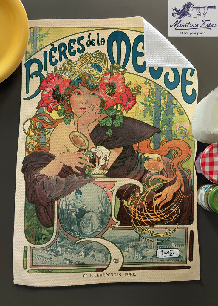 A colorful tea towel featuring a historical advertisement design with a woman, flowers, and text, representing the 'Bières de la Meuse' by Alphonse Mucha.