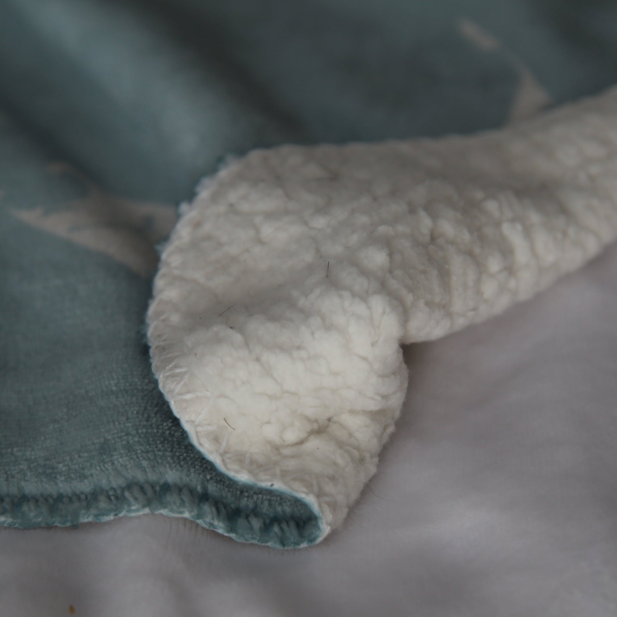 Close-up of sherpa fleece baby blanket with a focus on the edge.