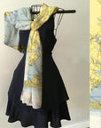 Black dress with a map-patterned scarf on a hanger against a light background